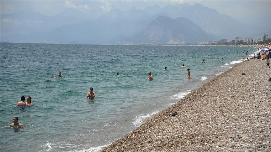 Antalya'da güneşli havayı fırsat bilen tatilciler denize girdi
