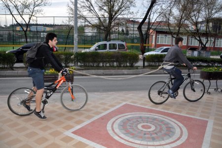 Arkadaşının bisikleti bozulunca beline ip sarıp 10 kilometre çekti