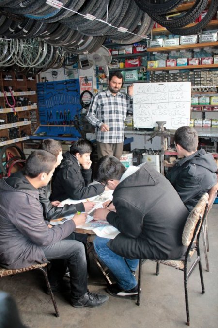 Bisiklet tamircisi iş yerinde Arapça kursu veriyor