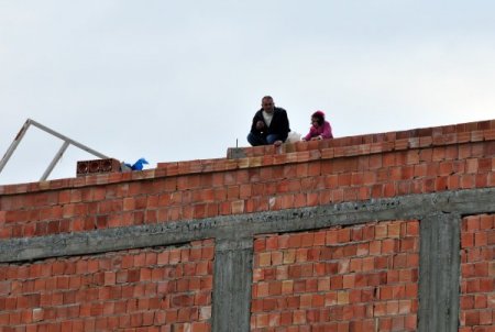 Eşi boşanmak isteyen adam çatıya çıktı, kızı üşüyünce eylemden vazgeçti