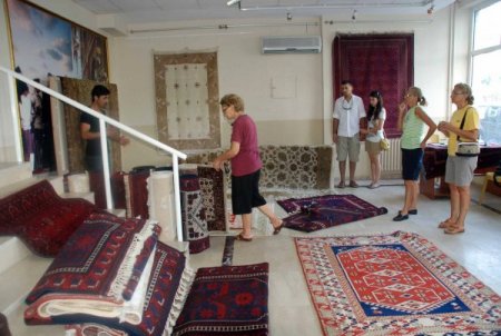 Köylülerin ürettiği Yörük kilimlerini muhtar pazarlıyor
