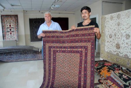 Köylülerin ürettiği Yörük kilimlerini muhtar pazarlıyor