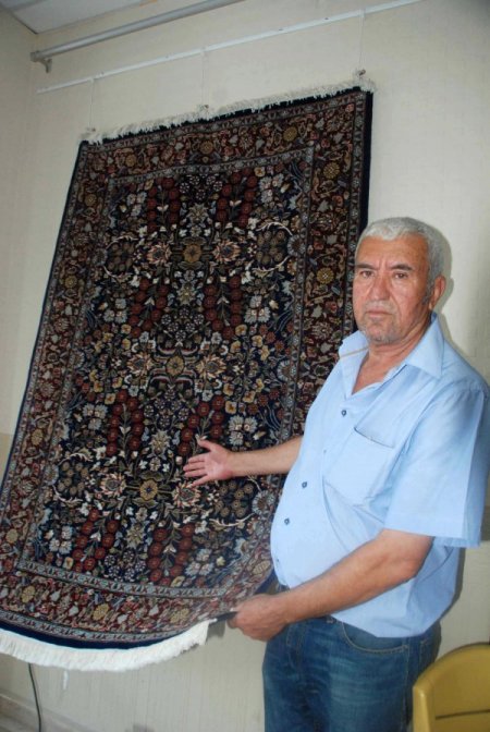Köylülerin ürettiği Yörük kilimlerini muhtar pazarlıyor