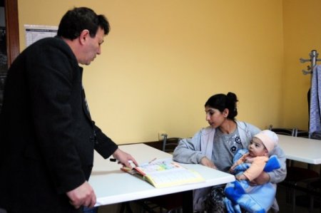 Kucağında Bebeğiyle Okuma Yazma Öğreniyor