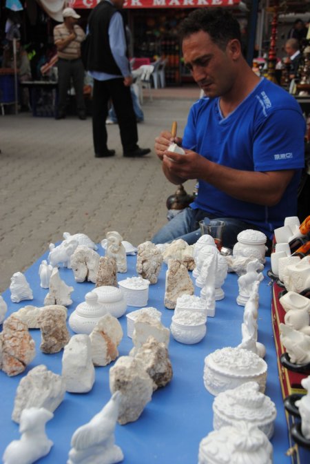 Lületaşından hediyelik eşya yapımını turistlere uygulamalı gösteriyor