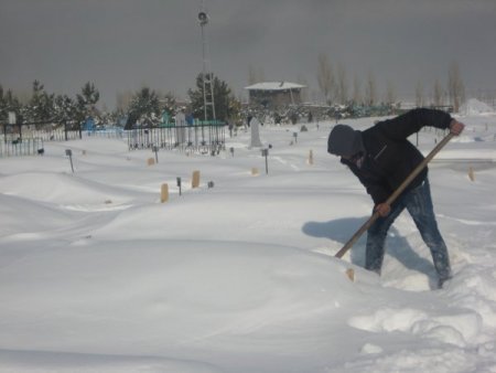 Okul harçlığını mezarların üzerindeki karı temizleyerek çıkarıyorlar