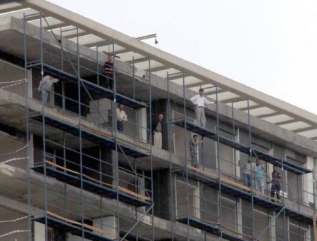 Parasını alamayan işçiler çatıya çıktı