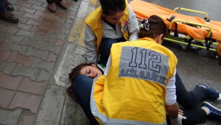 Şemsiye ve atkısıyla yaralı kızı yağmurdan korudu