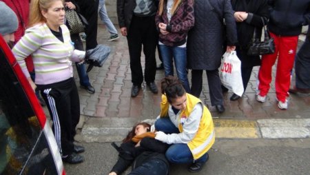 Şemsiye ve atkısıyla yaralı kızı yağmurdan korudu