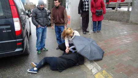 Şemsiye ve atkısıyla yaralı kızı yağmurdan korudu