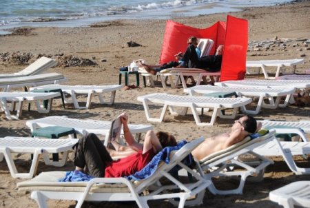 Turistler, güzel havanın keyfini güneşlenerek çıkardı