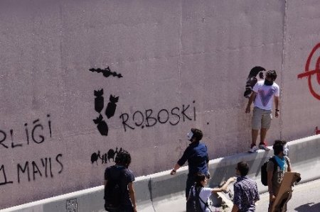 Yüzlerini kapatıp alt geçitlere slogan yazdılar