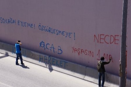 Yüzlerini kapatıp alt geçitlere slogan yazdılar